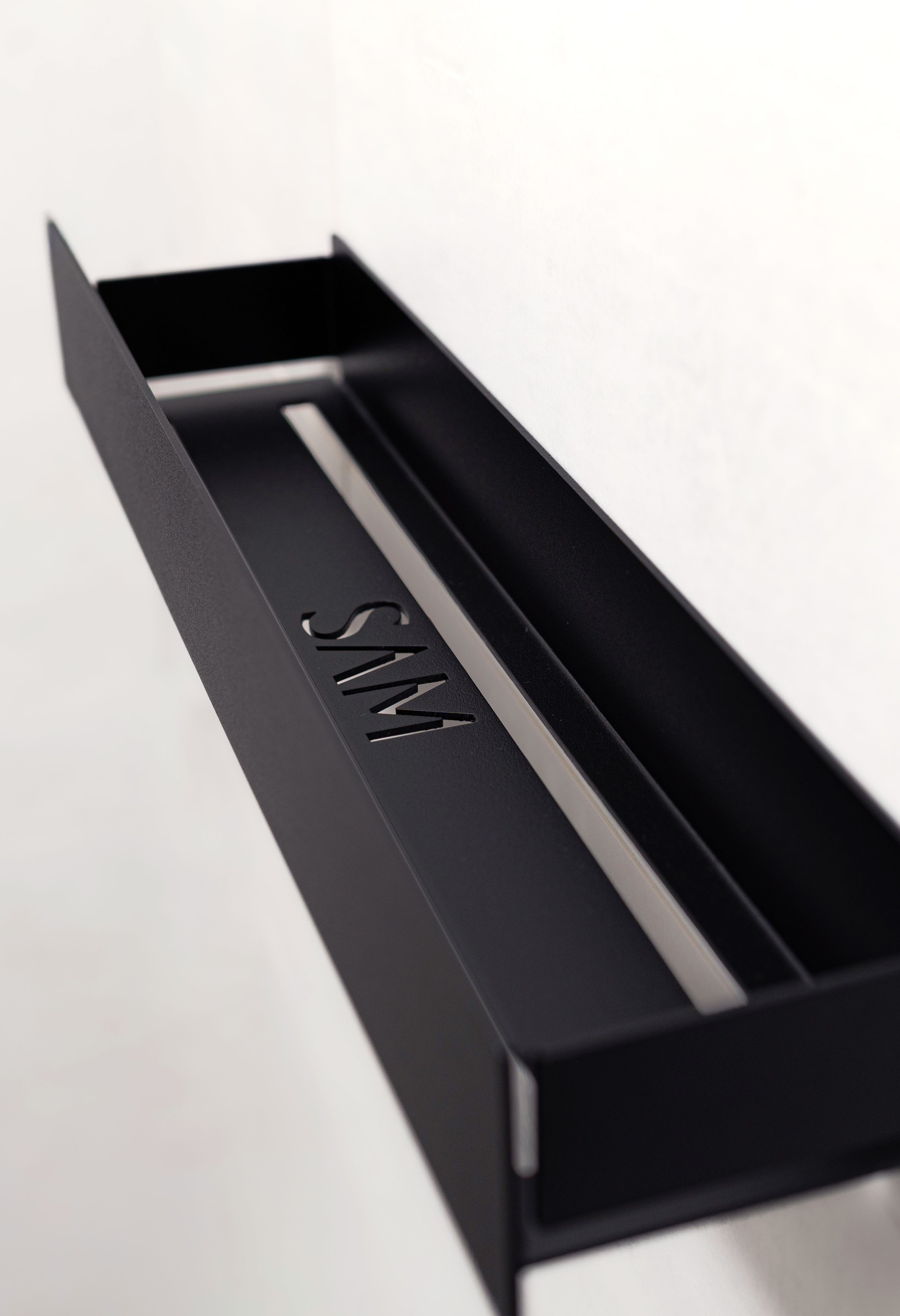 Duschablage KORSIKA ohne Bohren, Schwarz Close-Up Ansicht schräg von oben, welche Lasercut Ausschnitte für Wasserablauf zeigt.