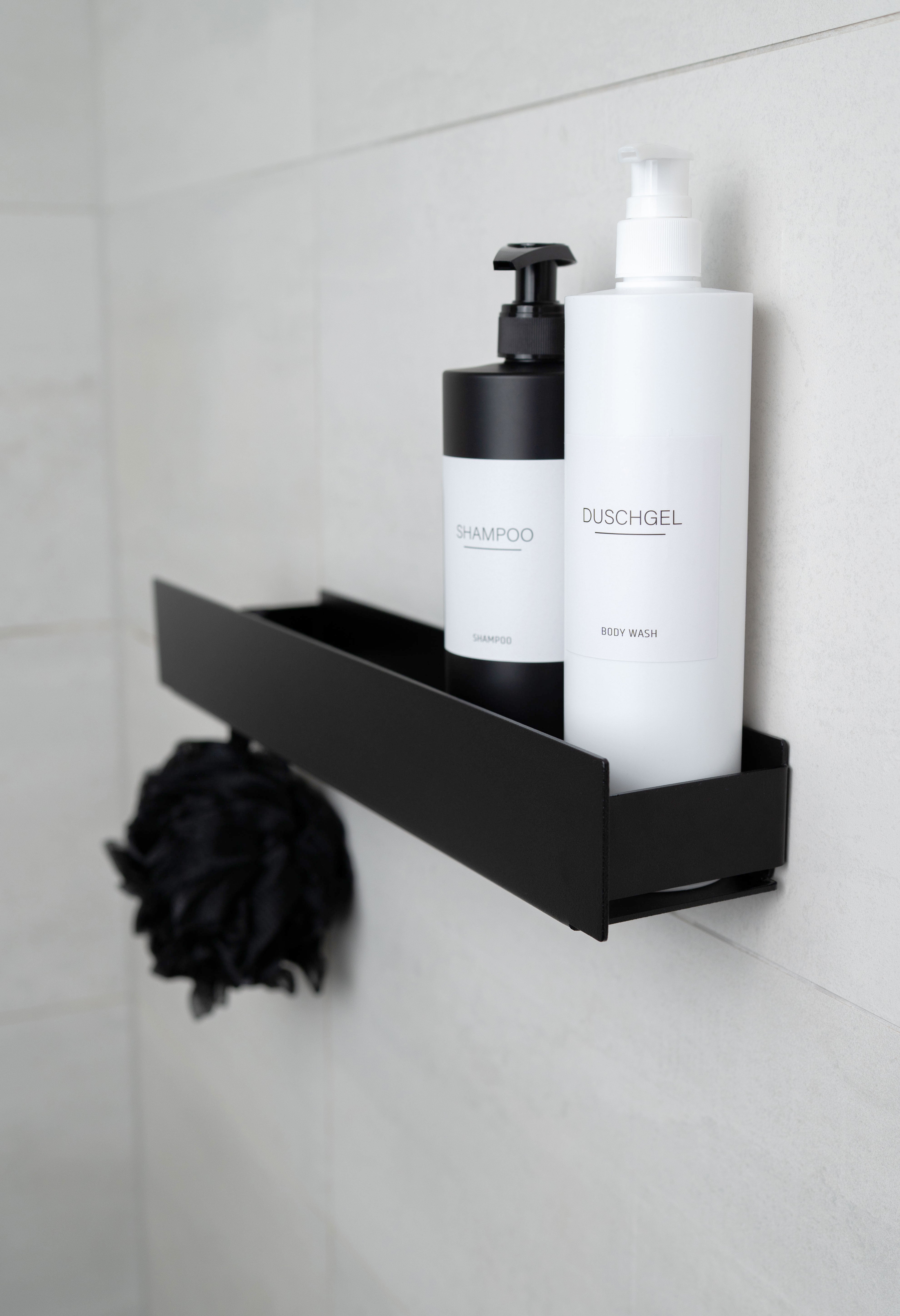 Design Duschablage aus Metall in Schwarz, KORSIKA zum Kleben, stilvoll arrangiert mit Duschutensilien.