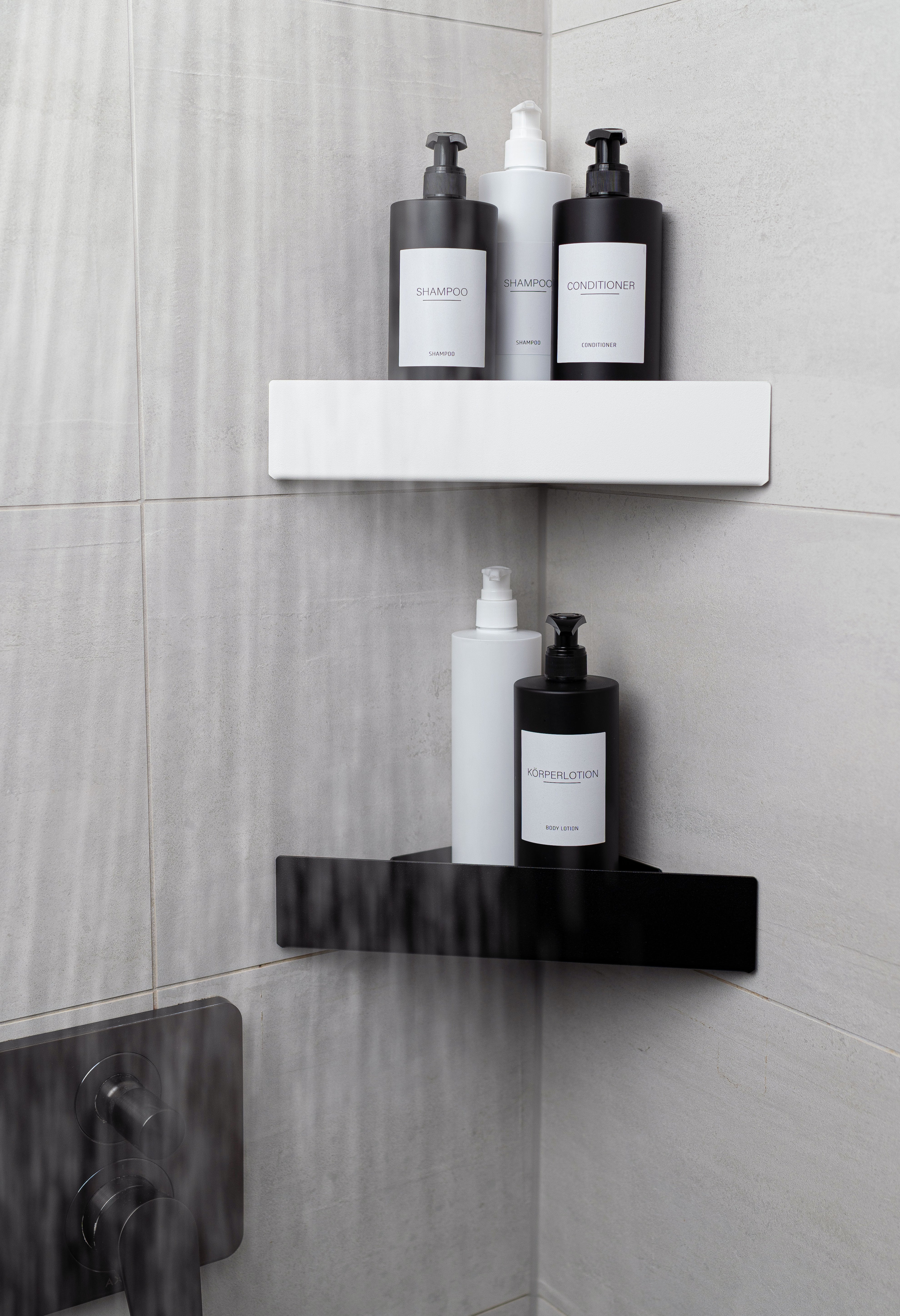 Eckwand Duschablage Monte Carlo zum Kleben ohne Bohren in den Farben schwarz und weiß mit modernen Pumpflaschen passend in schwarz und weiß. Wasser der Dusche prasselt vor regalen herunter.