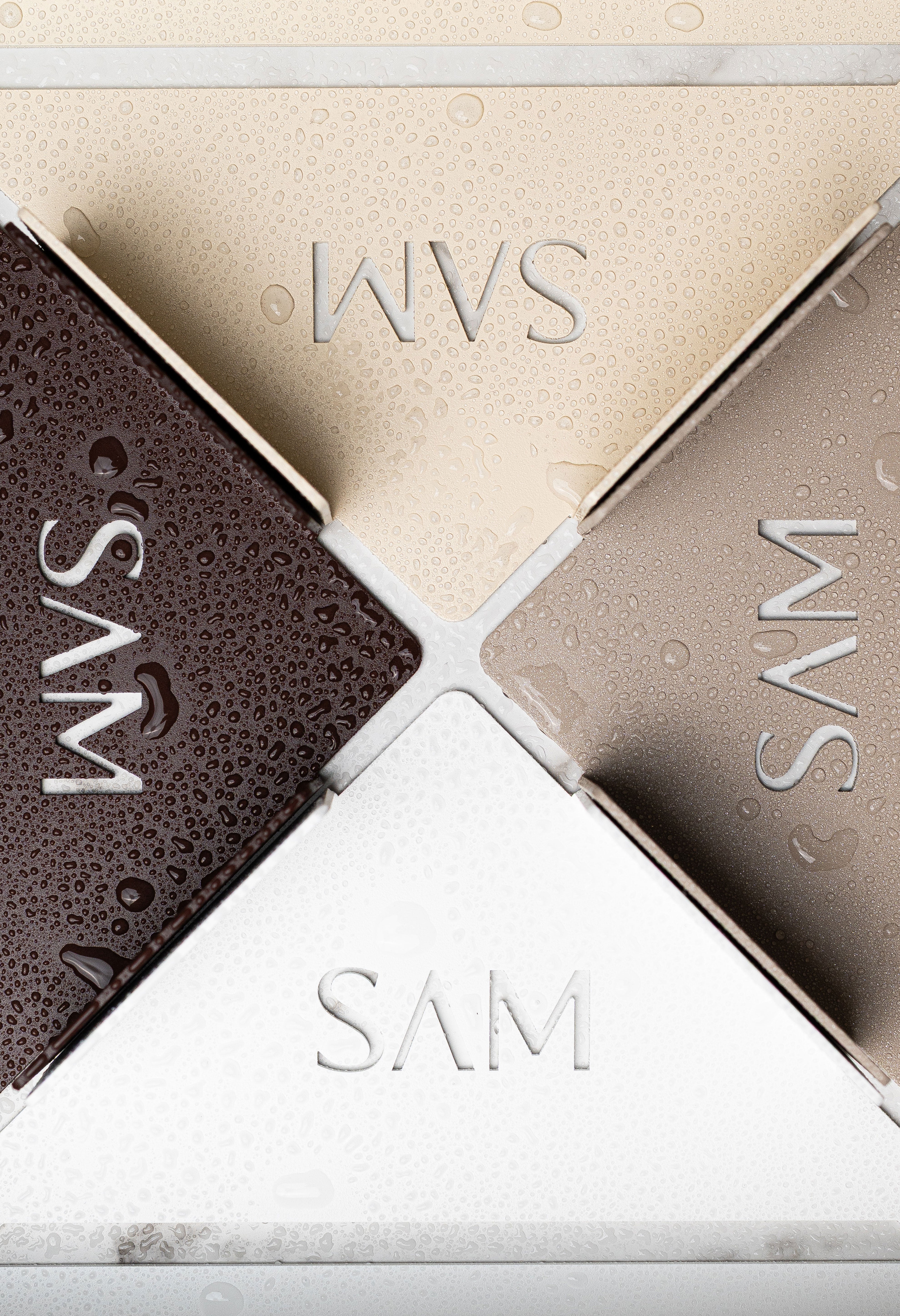 Close Up Duschablge Monte Carlo zum Kleben ohne Bohren aus pulverbeschichtetem Metall in den Farben Beige, Champagner, Weiß und Marone in einem Flatlay. Wassertropfen perlen auf den Oberflächen ab.