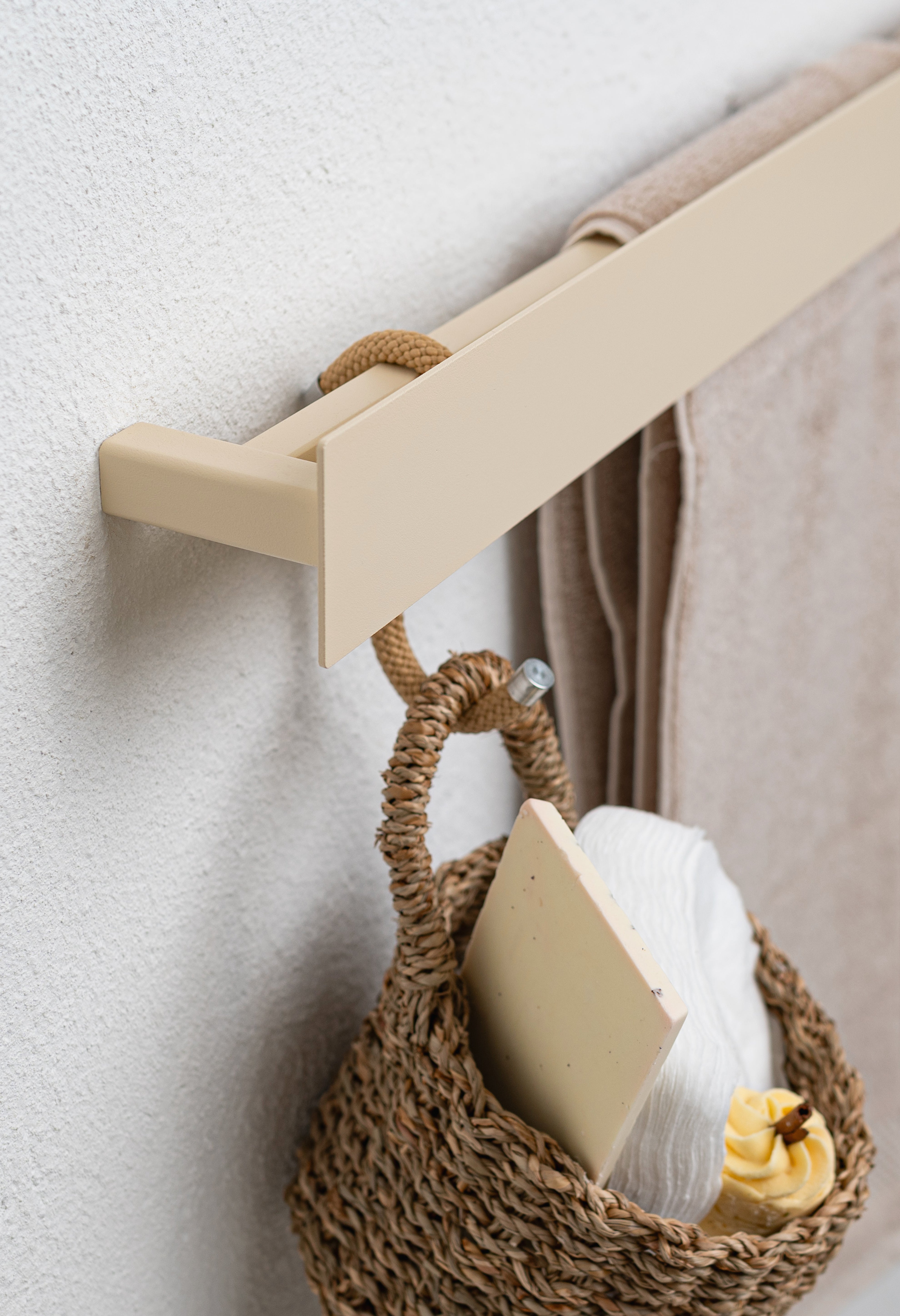 Seitliche Nahaufnahme handtuchhalter Beige mit S-haken und Körbchen gefüllt mit Kosmetikutensilien