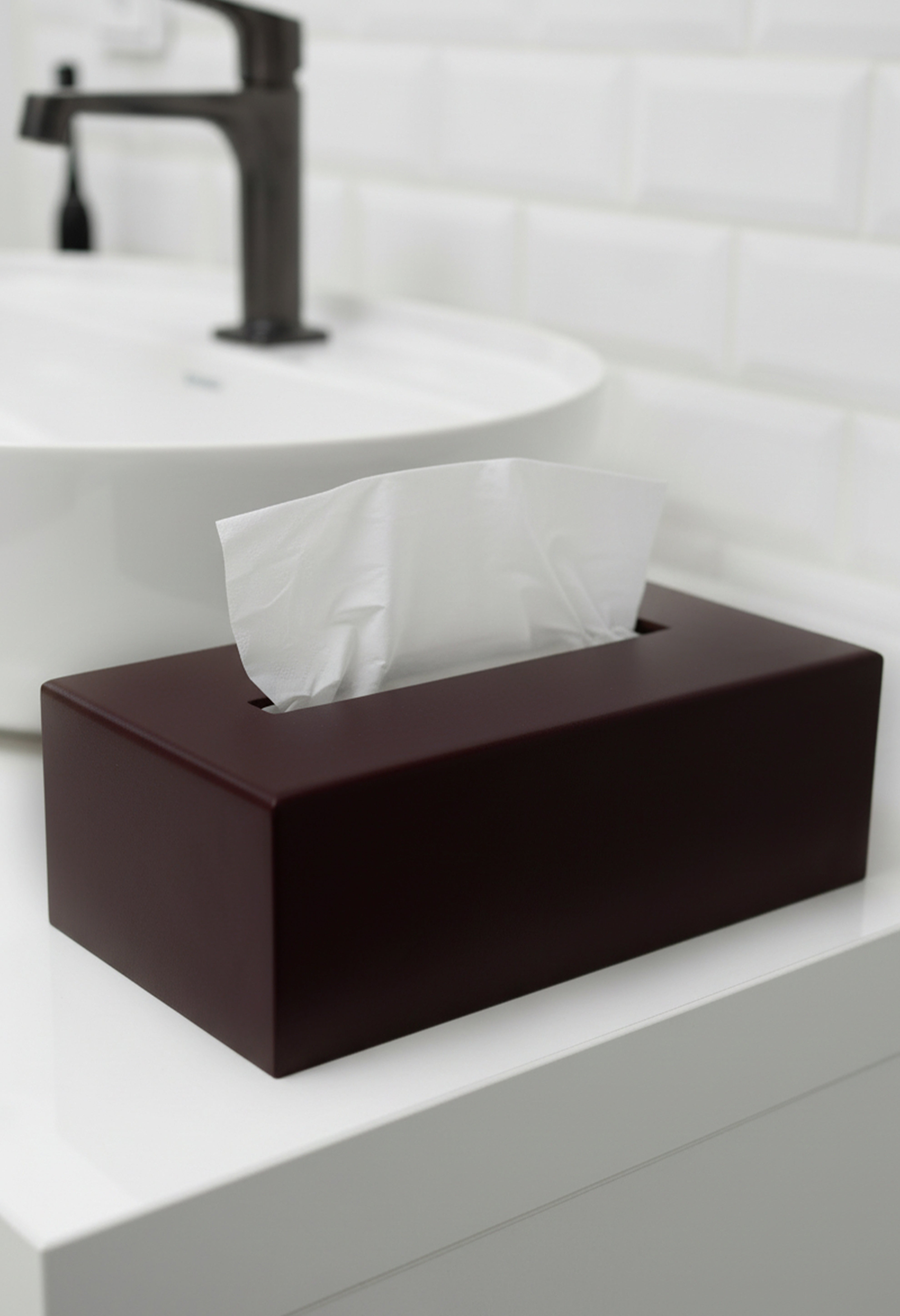 Kosmetiktuchbox in Marone auf in einem hellen weißen Bad.