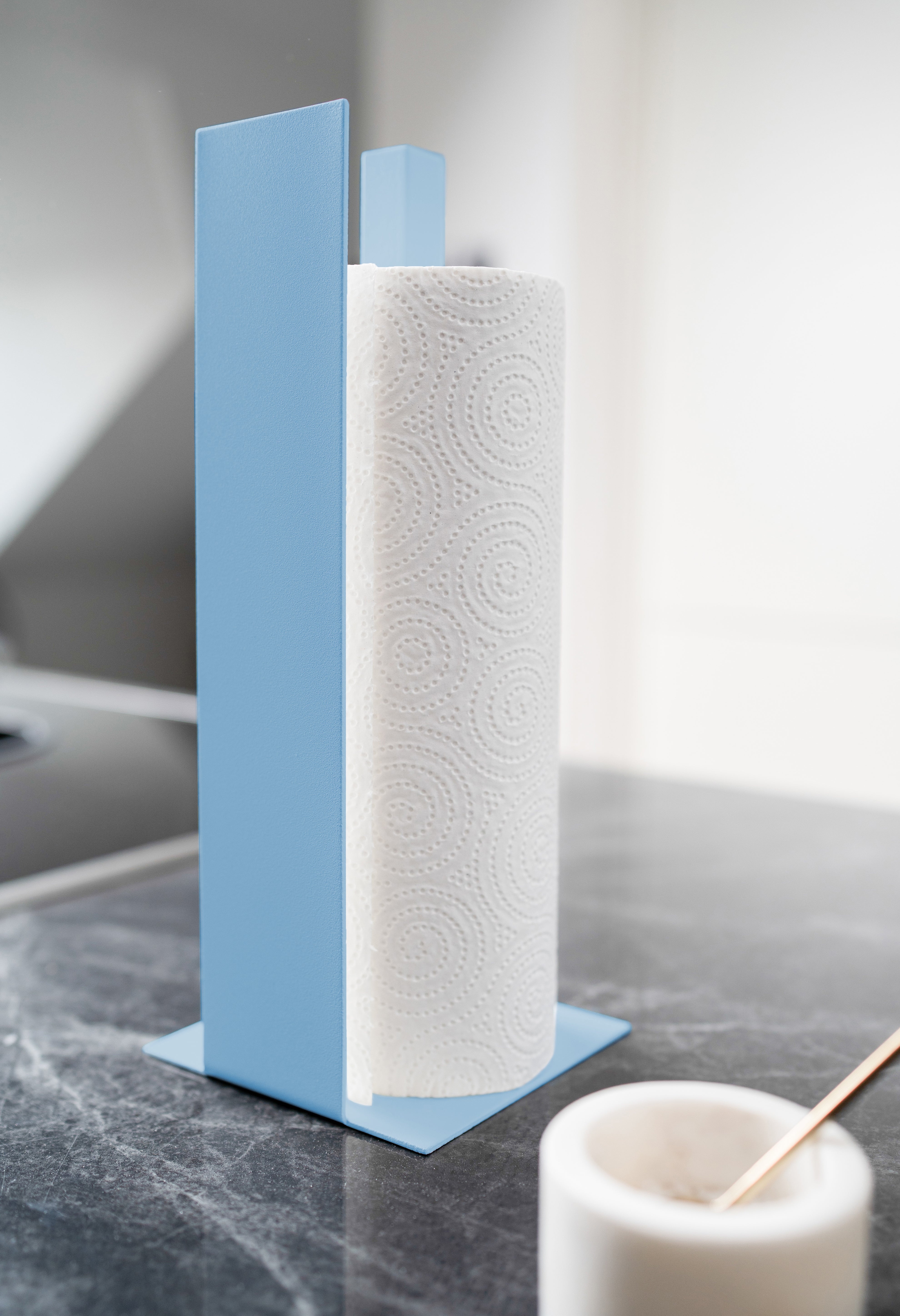 Küchenrollenhalter in metallic blau mit Blende vorne auf schwarzer Mamorplatte