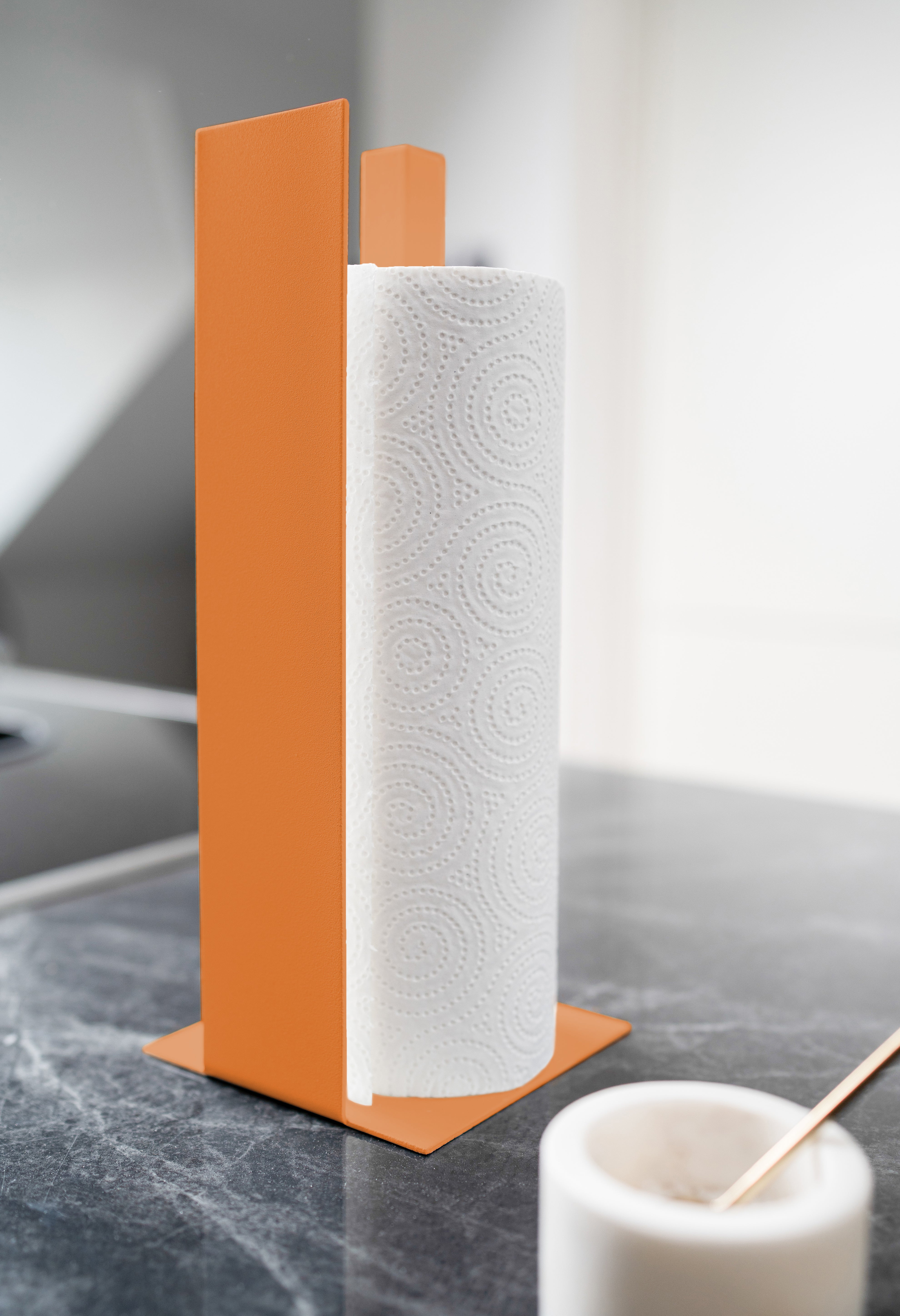 Küchenrollenhalter in orange mit Blende vorne auf schwarzer Mamorplatte
