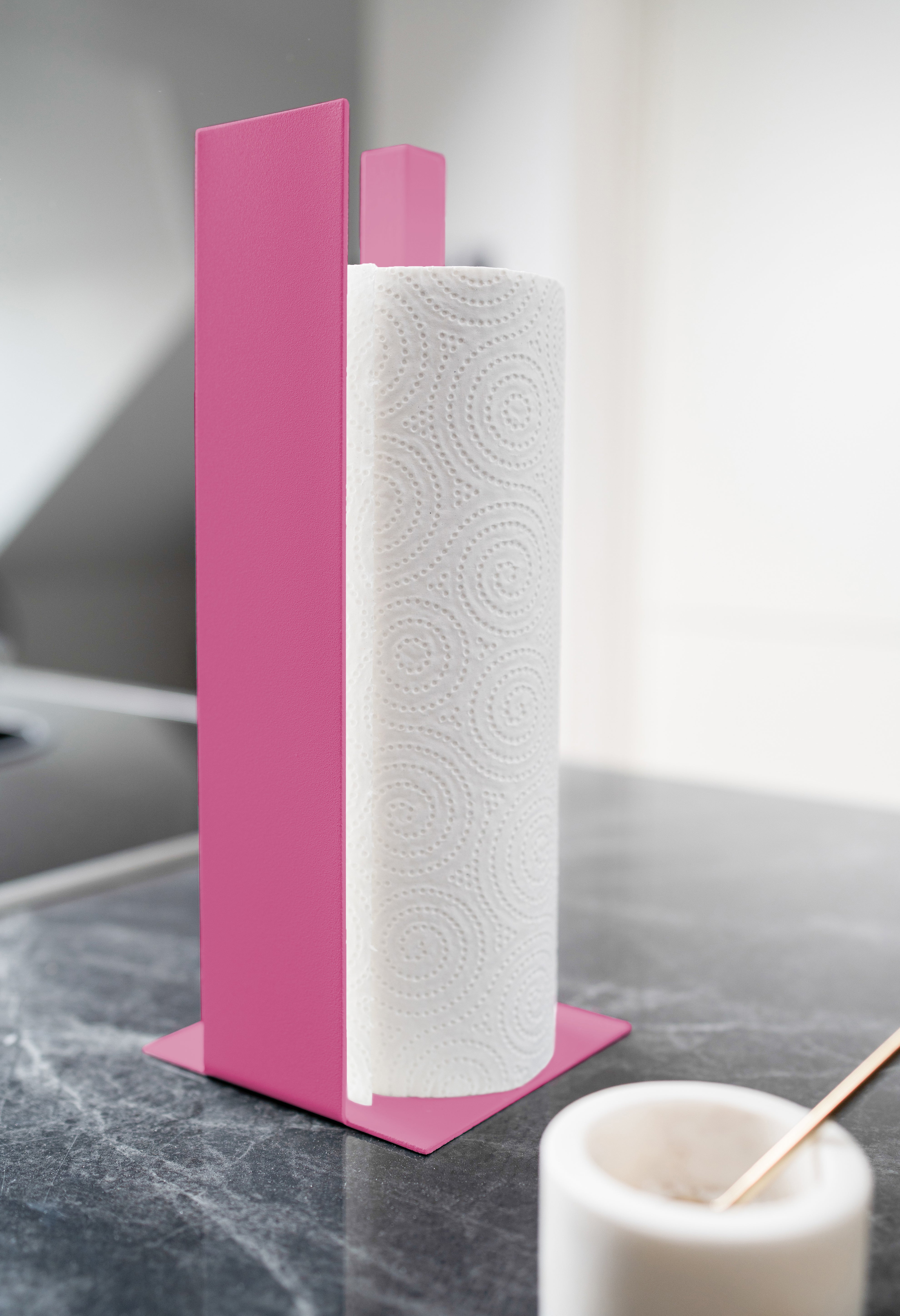 Küchenrollenhalter in rosa mit Blende vorne auf schwarzer Mamorplatte