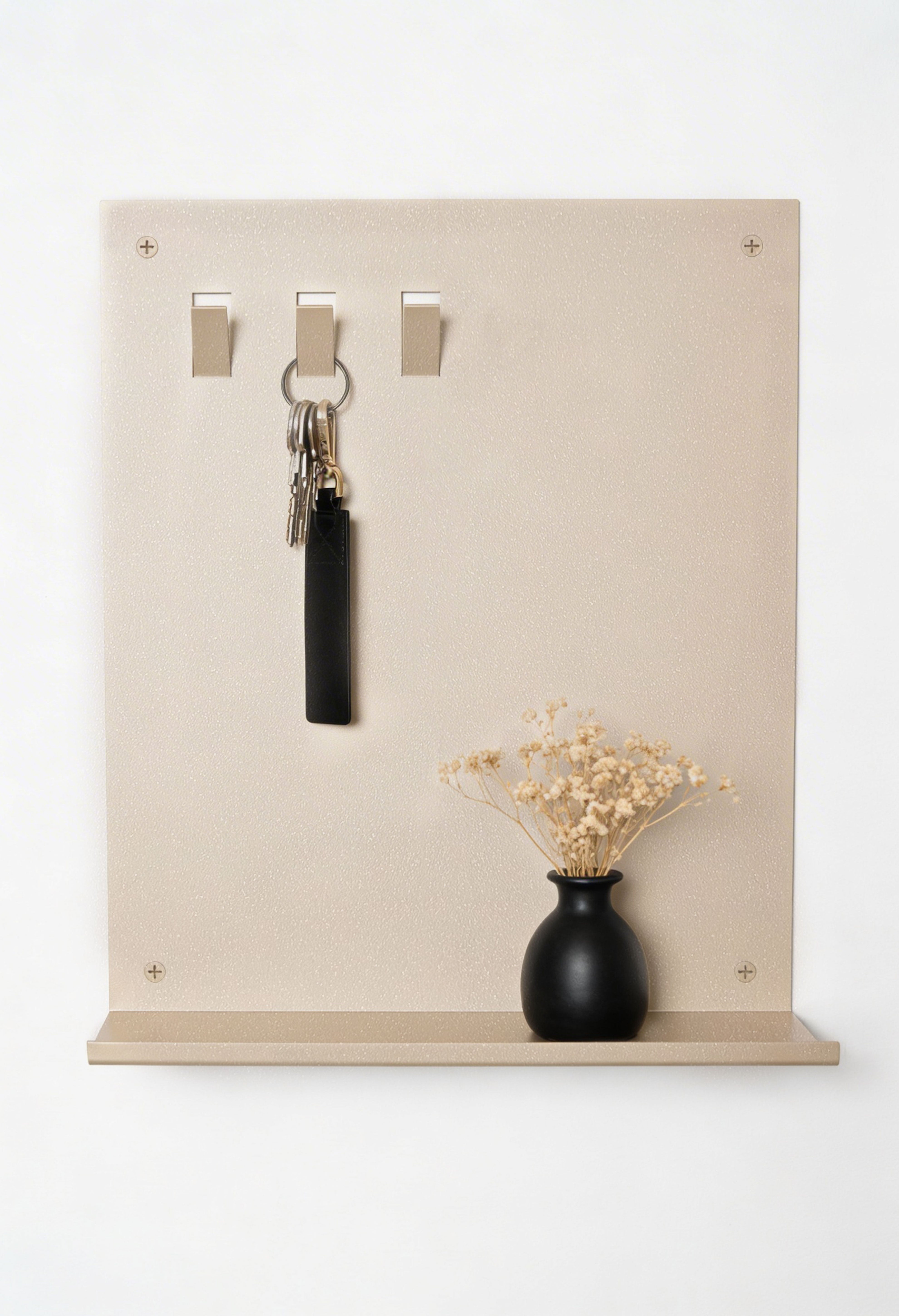 Frontansicht pulverbeschichtetes Metall Schlüsselbrett in Farbe Champagner mit drei Haken oben und einer Ablagefläche unten. Es hängt ein Schlüsselbund und auf der Ablagefläche ist ein kleiner Geldbeutel in schwarz aufgestellelt.
