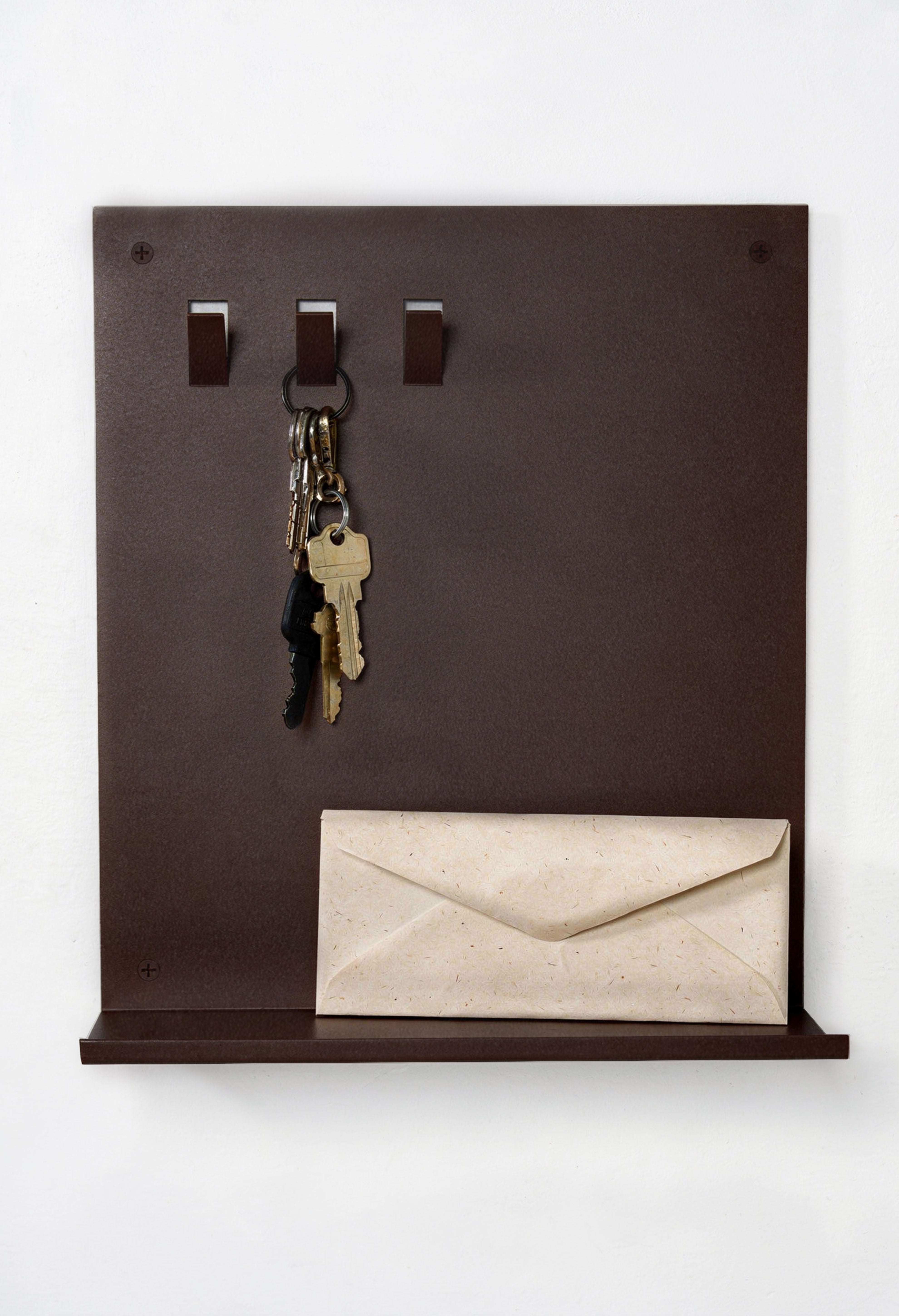 Frontansicht Marone farbenes pulverbeschichtetes Metall Schlüsselbrett mit drei Haken oben und einer Ablagefläche unten. Es hängt ein Schlüsselbund und auf der Ablagefläche ist ein kleiner Geldbeutel in schwarz aufgestellelt.