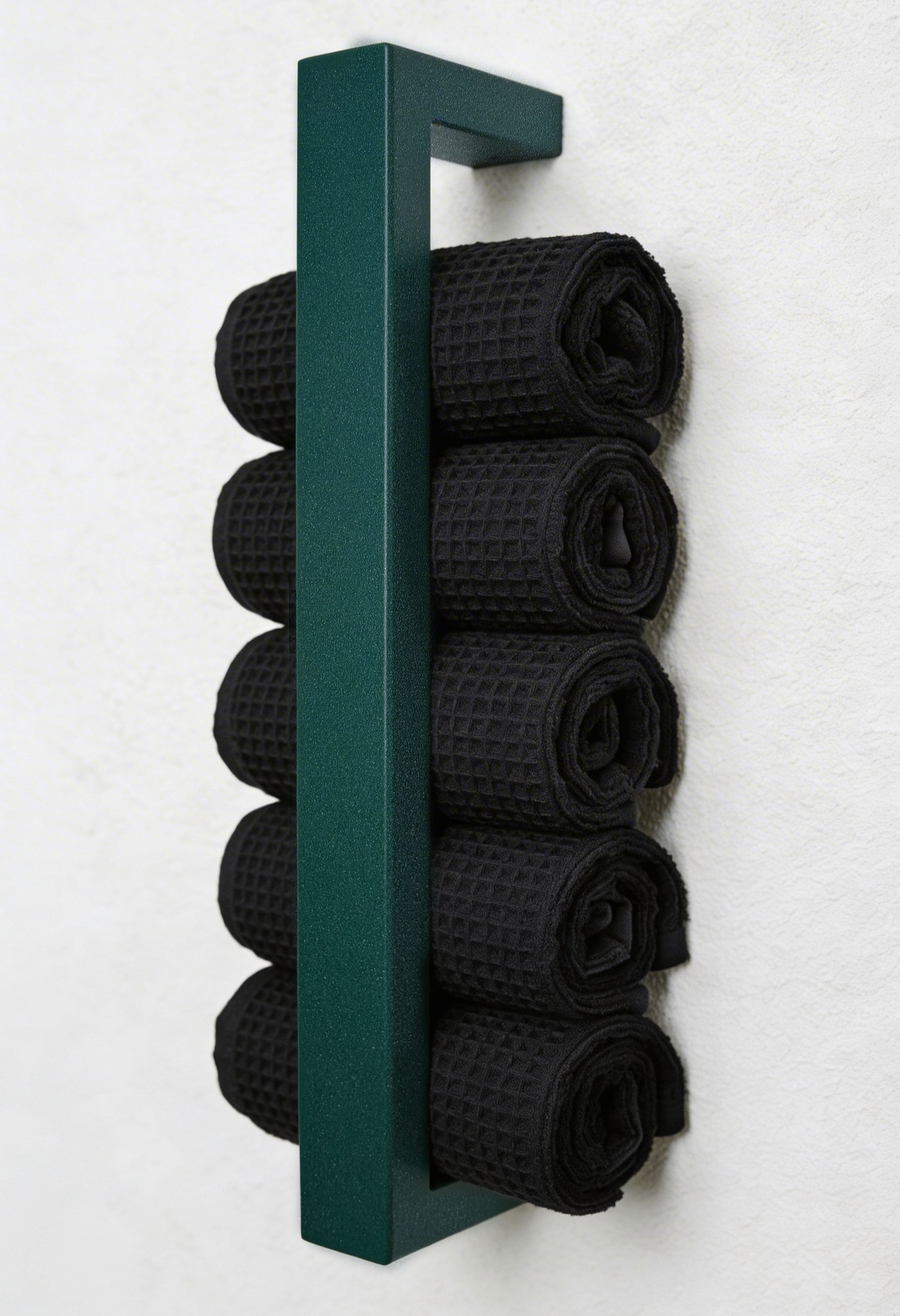Sparkling Green, moderner Handtuchhalter aus pulverbeschichtetem Metall, der an einer Wand montiert ist. Der Halter bietet Platz für mehrere gerollte Handtücher und fügt sich dekorativ in das Badezimmer ein. Eine stilvolle, platzsparende Lösung zur Aufbewahrung von Handtüchern.