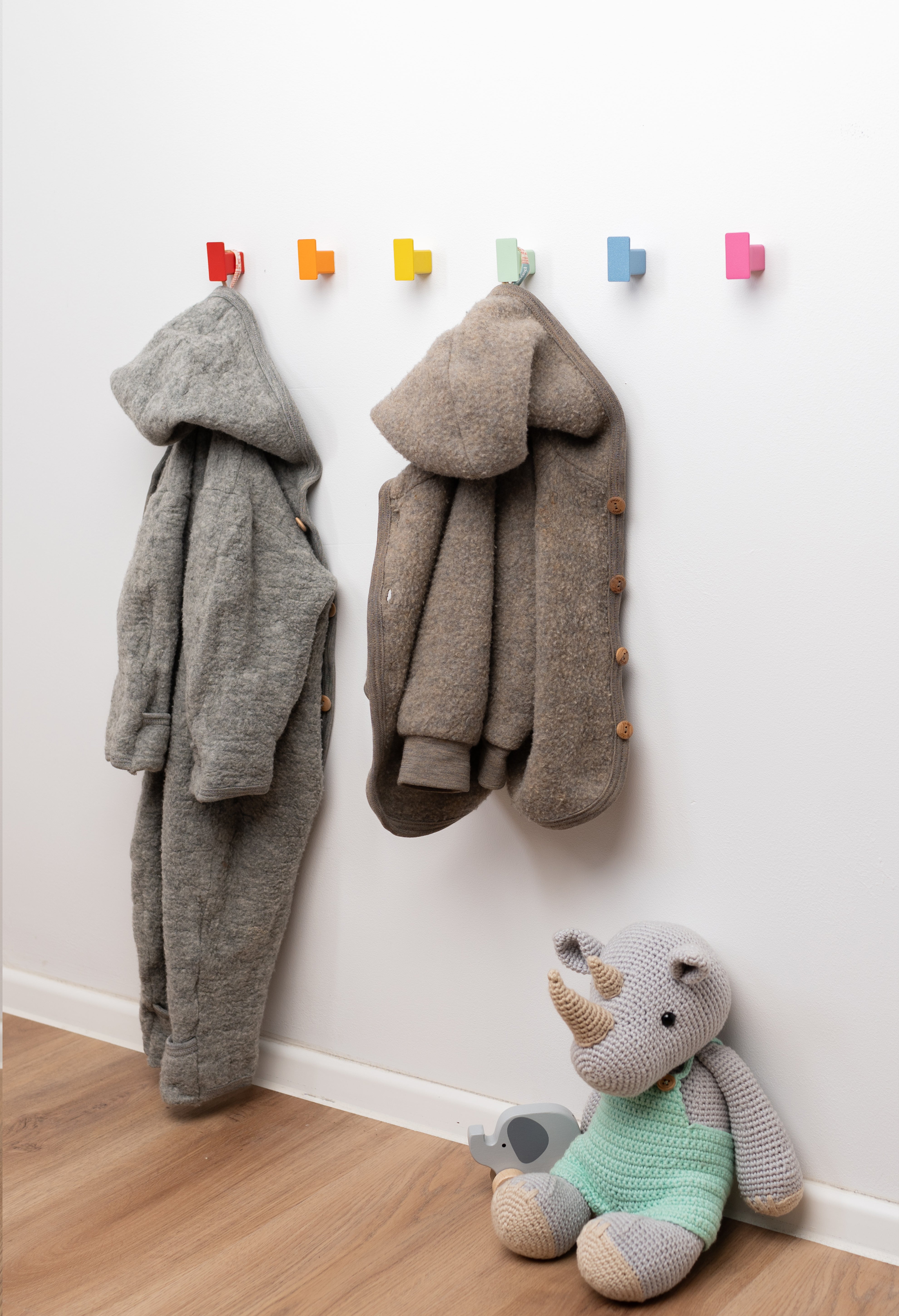 Farbenfrohe Kindergarderobe mit sechs bunten Haken in Regenbogenfarben, ideal für Jacken und Taschen im Kinderzimmer.