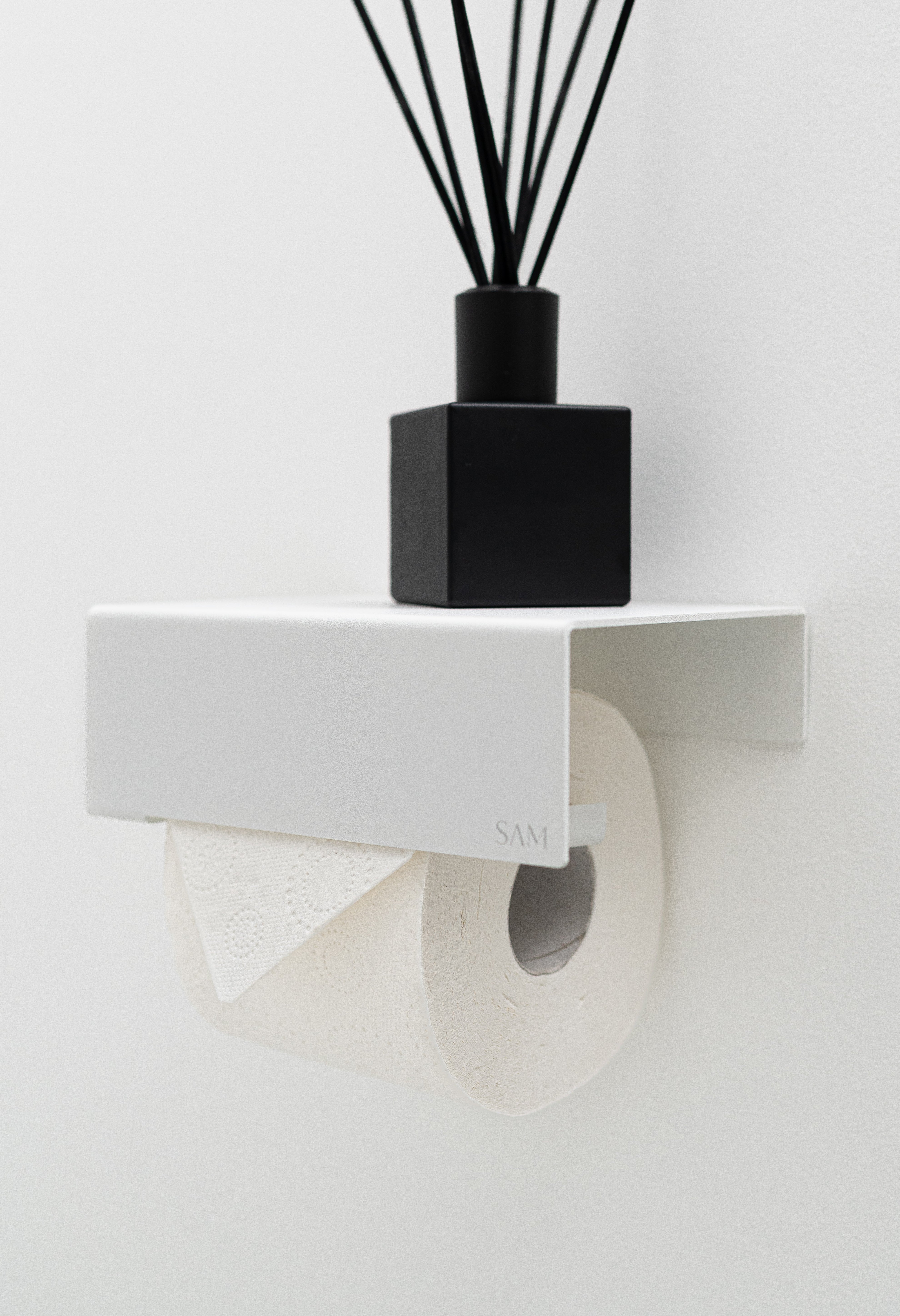 Toilettenpapierhalter LILLE zum Kleben ohne Bohren in seitlicher Ansicht in Farbe weiß mit Raumduft auf integrierter Ablage